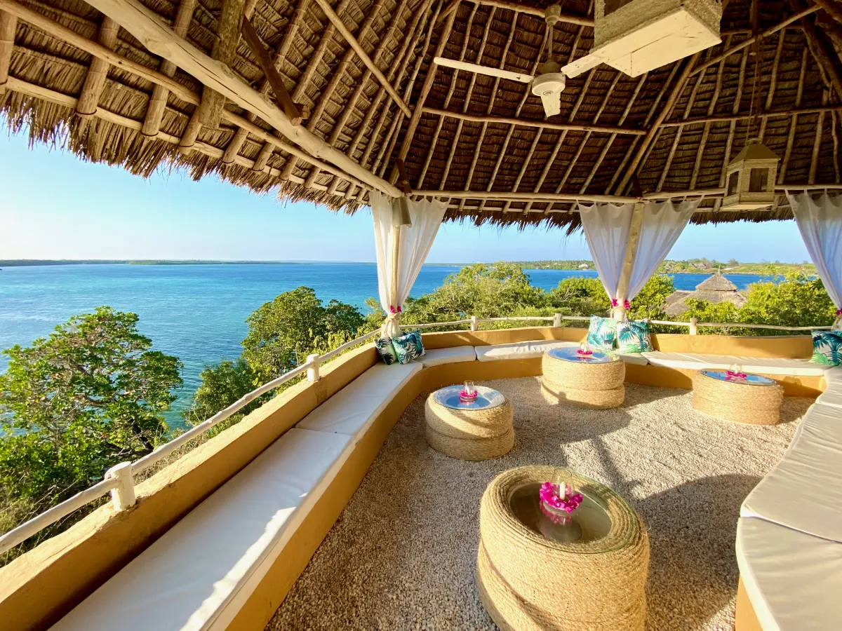 The thatched panoramic lounge with curtained arches and cushioned seating looking out over the Indian Ocean